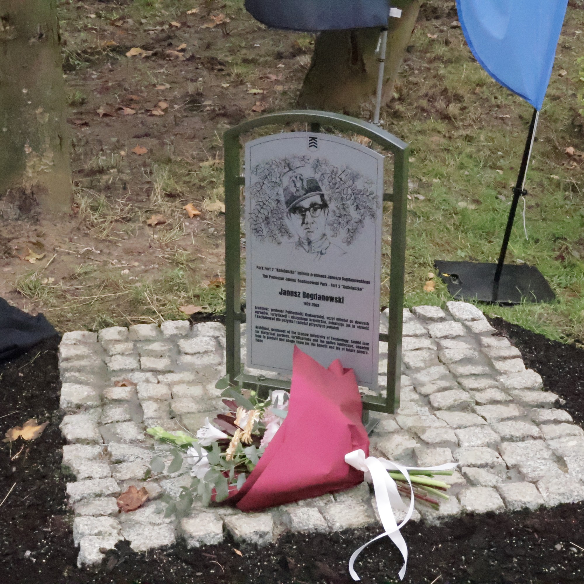 Tablica upamiętnia patrona parku. Wizerunek nawiązuje do zdjęcia wykonanego przez Józefa Gabriela Budziłę, przyjaciela Profesora. Przedstawia Janusza Bogdanowskiego w mundurze wojskowym ojca, Wincentego Bogdanowskiego, majora armii austro-węgierskiej; formacji, w której służyło wielu Polaków, kadra przyszłego wojska polskiego. Fot.: Tomasz Malec